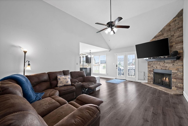 living room with a stone fireplace, ceiling fan with notable chandelier, high vaulted ceiling, and dark hardwood / wood-style floors