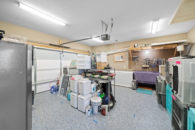 garage featuring a wall mounted air conditioner, a garage door opener, and stainless steel refrigerator