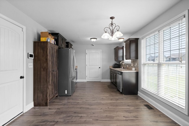 kitchen with appliances with stainless steel finishes, dark hardwood / wood-style flooring, a wealth of natural light, and sink