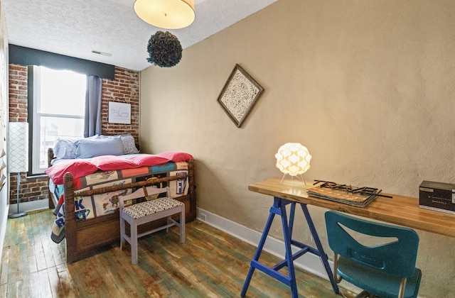 bedroom with dark hardwood / wood-style flooring and a textured ceiling