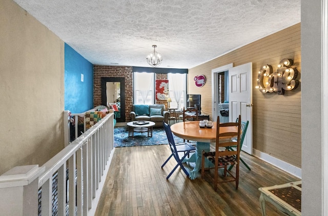 dining room featuring a chandelier, wood-type flooring, and a textured ceiling