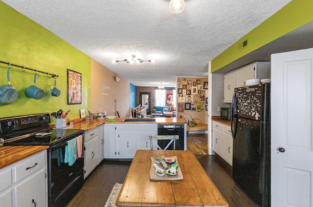 kitchen with black appliances, dark hardwood / wood-style floors, white cabinetry, and sink