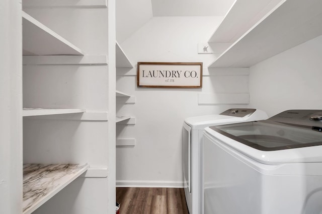 clothes washing area with dark hardwood / wood-style flooring and independent washer and dryer