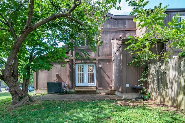 rear view of house with a yard and cooling unit