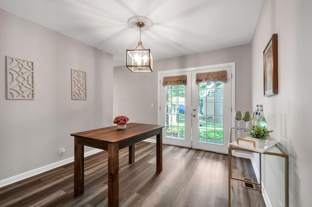 dining room featuring french doors, an inviting chandelier, and dark wood-type flooring