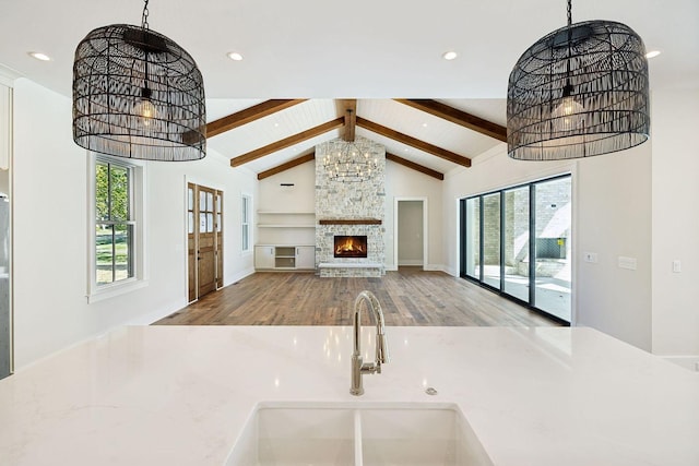 interior space with a fireplace, decorative light fixtures, hardwood / wood-style flooring, and beamed ceiling