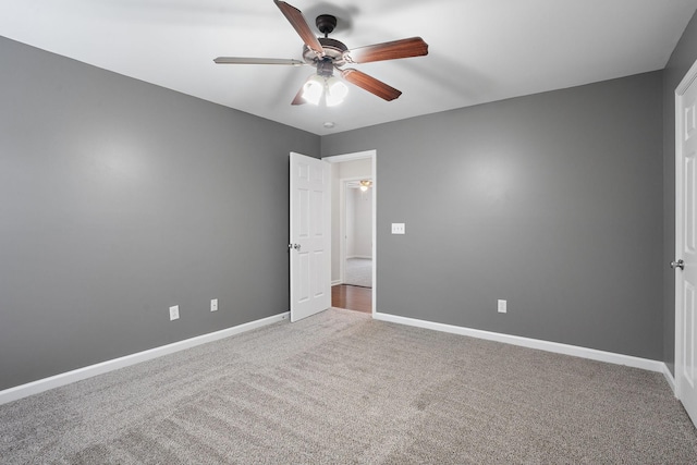 carpeted spare room featuring ceiling fan