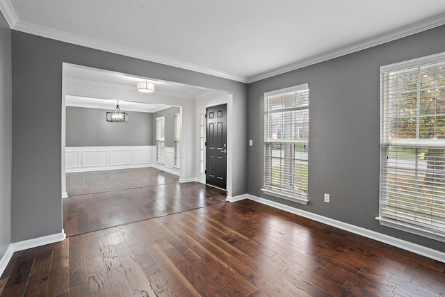 entryway with a chandelier, dark hardwood / wood-style flooring, plenty of natural light, and crown molding