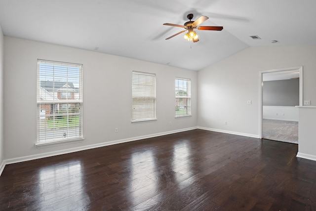 unfurnished room featuring plenty of natural light, ceiling fan, dark wood-type flooring, and vaulted ceiling