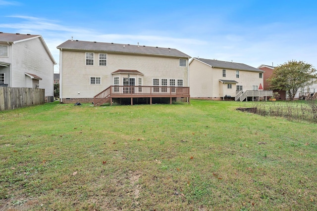 rear view of house featuring a deck and a yard