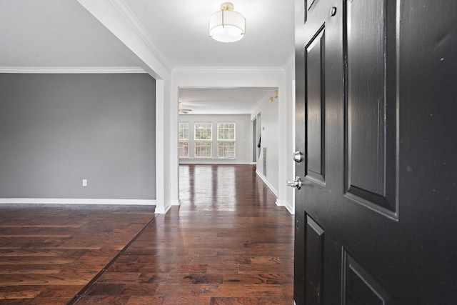 entryway with ceiling fan, dark wood-type flooring, and ornamental molding