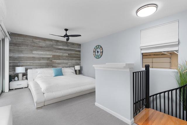 bedroom with ceiling fan, wooden walls, and carpet floors