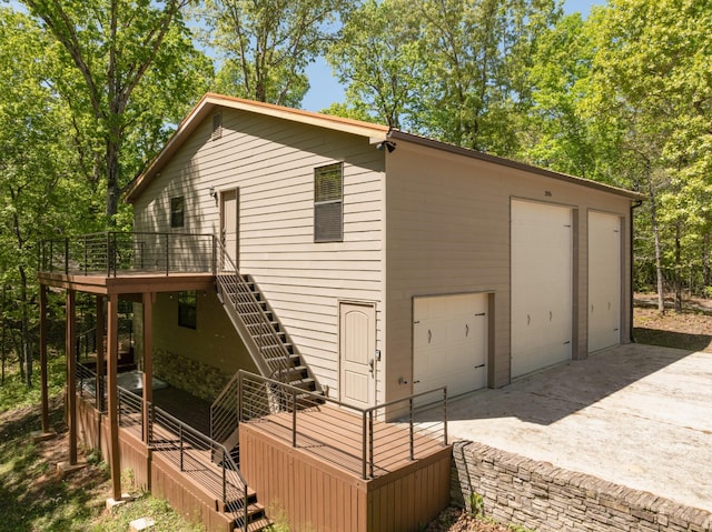 back of property featuring a garage and a deck