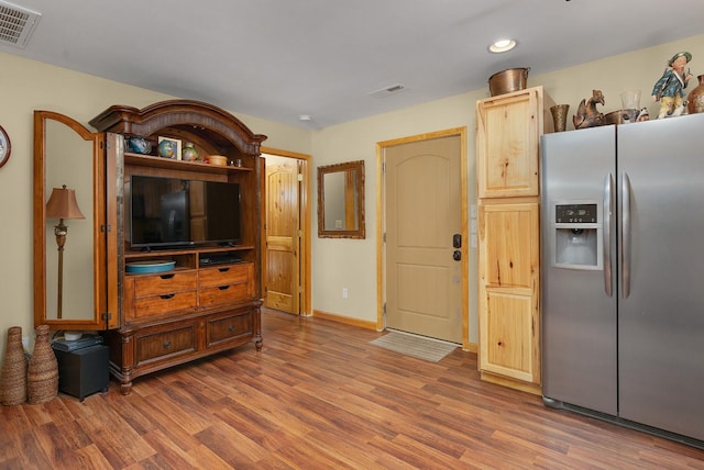 kitchen featuring dark hardwood / wood-style flooring and stainless steel fridge with ice dispenser