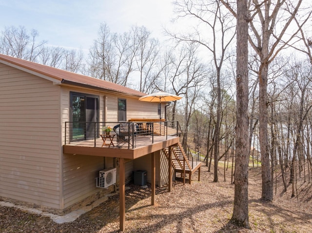 back of house with a wooden deck and central AC unit