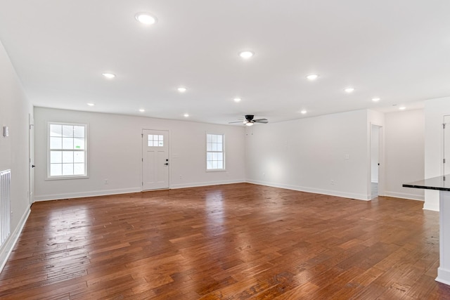 unfurnished living room featuring ceiling fan and dark hardwood / wood-style flooring