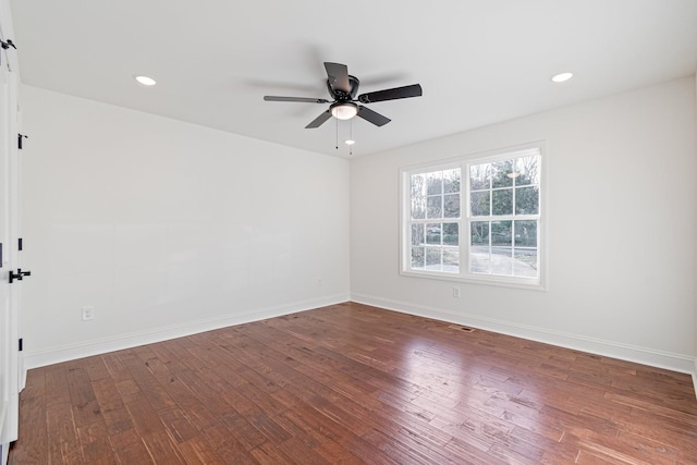 empty room featuring ceiling fan and dark hardwood / wood-style flooring