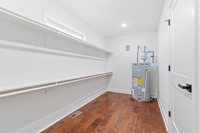 walk in closet featuring dark hardwood / wood-style floors and electric water heater