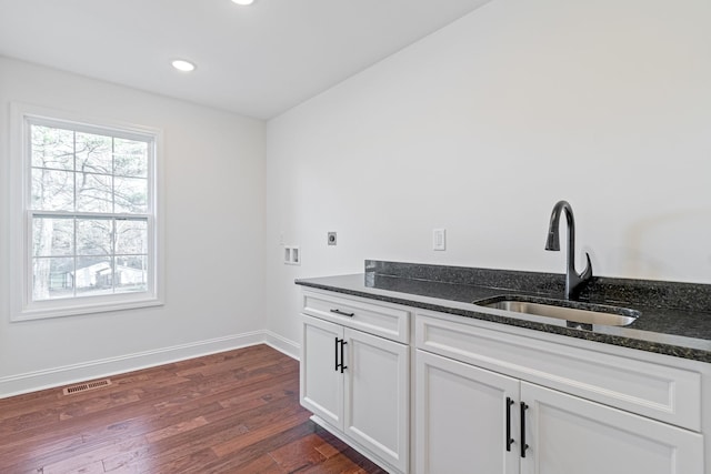 interior space with sink, cabinets, washer hookup, electric dryer hookup, and dark hardwood / wood-style flooring