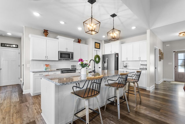 kitchen with white cabinets, an island with sink, and appliances with stainless steel finishes