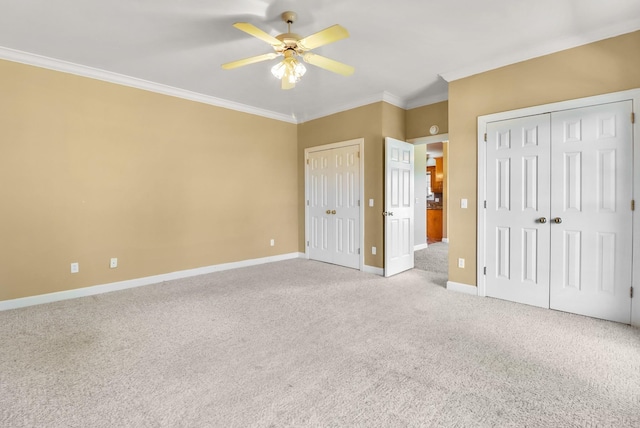 unfurnished bedroom with ceiling fan, crown molding, light carpet, and multiple closets