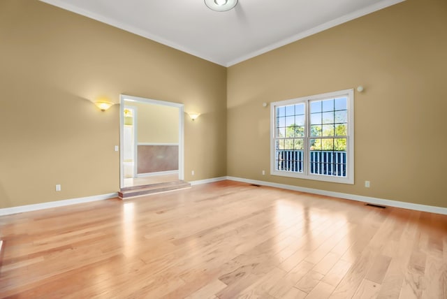 empty room featuring light hardwood / wood-style floors and ornamental molding