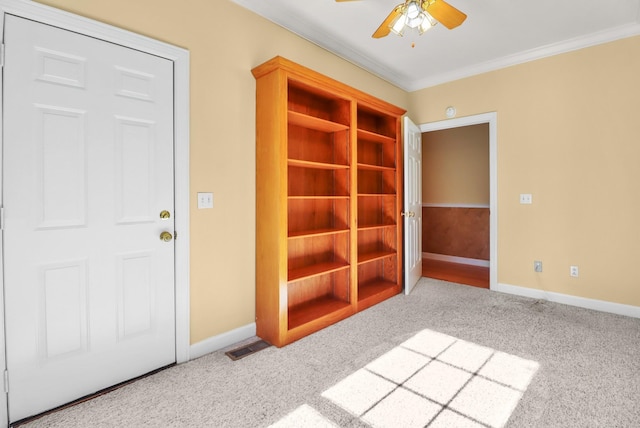 carpeted spare room with ceiling fan and crown molding