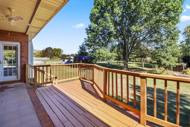 wooden deck featuring ceiling fan and a yard