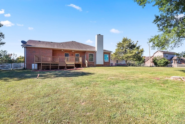 back of house featuring a lawn, ceiling fan, and a deck