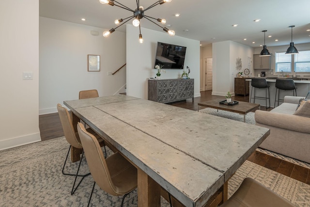 dining room with dark hardwood / wood-style floors, an inviting chandelier, and sink