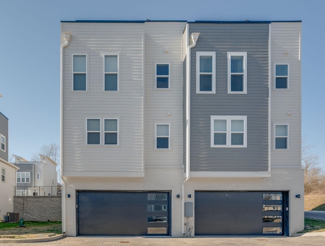 view of front of property with cooling unit and a garage