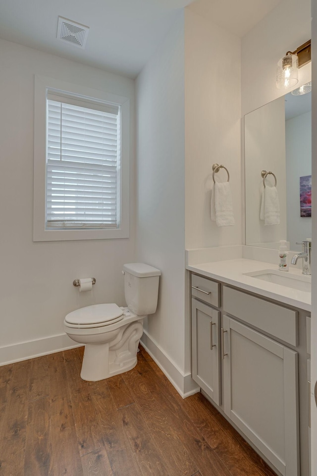 bathroom with hardwood / wood-style flooring, vanity, and toilet