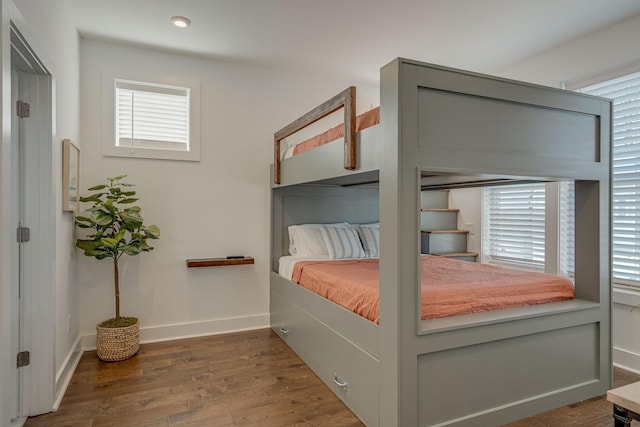 bedroom with dark hardwood / wood-style floors and multiple windows