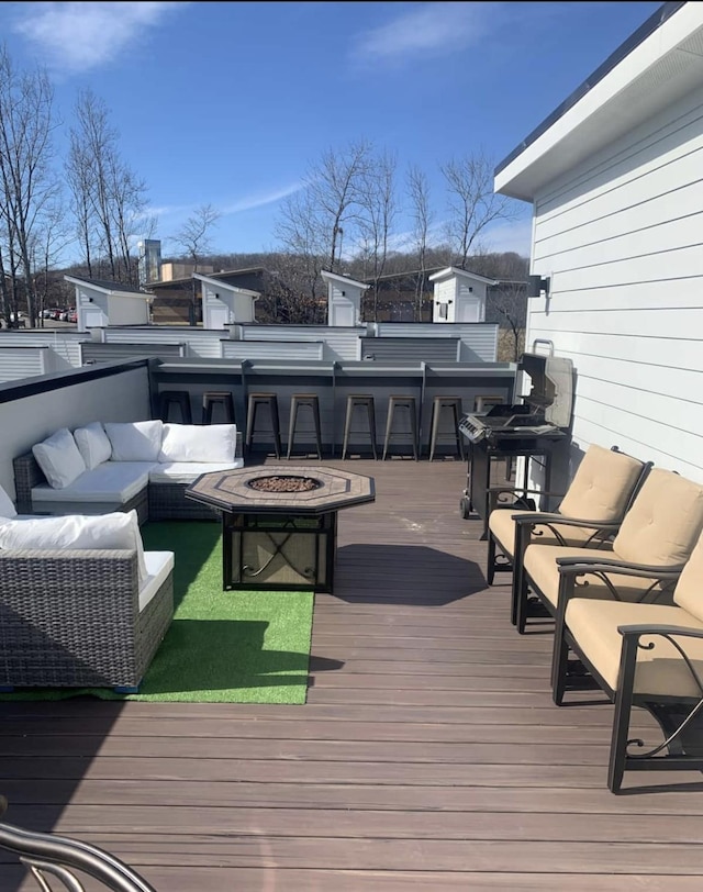 wooden deck featuring an outdoor living space with a fire pit