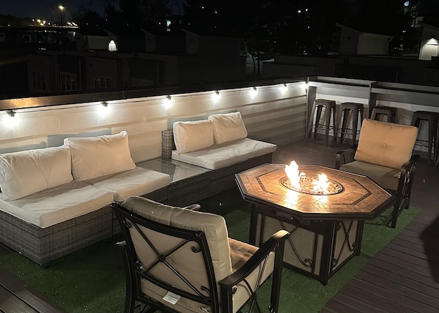 wooden deck with an outdoor living space with a fire pit and an outdoor bar