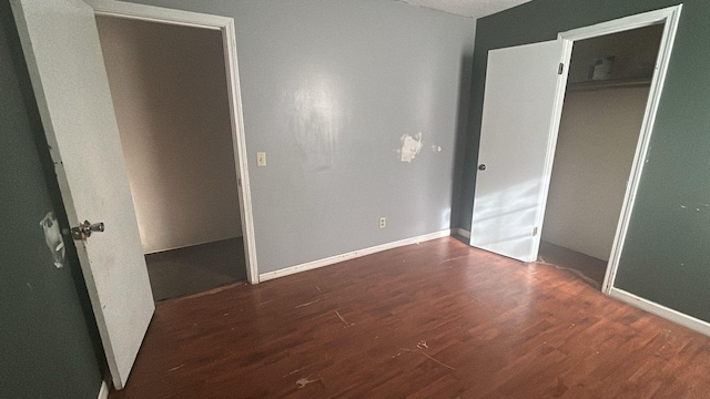 unfurnished bedroom featuring dark hardwood / wood-style floors and a closet