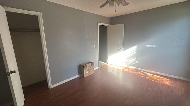 unfurnished bedroom with ceiling fan, dark wood-type flooring, and a closet