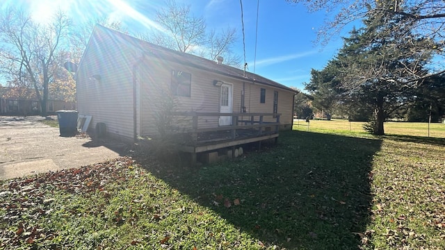 view of property exterior with a yard and a deck