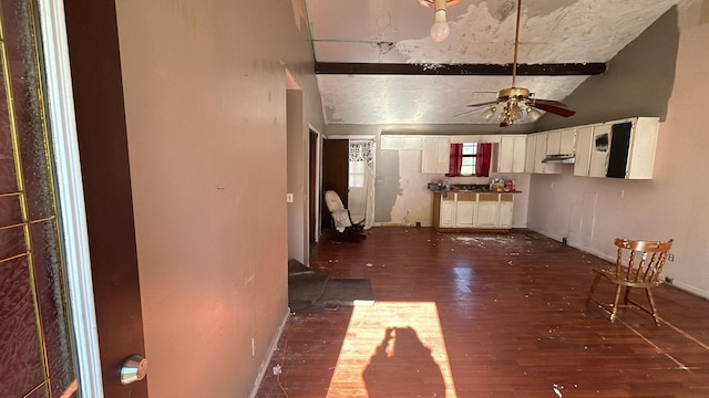 unfurnished living room featuring lofted ceiling with beams, ceiling fan, and dark wood-type flooring