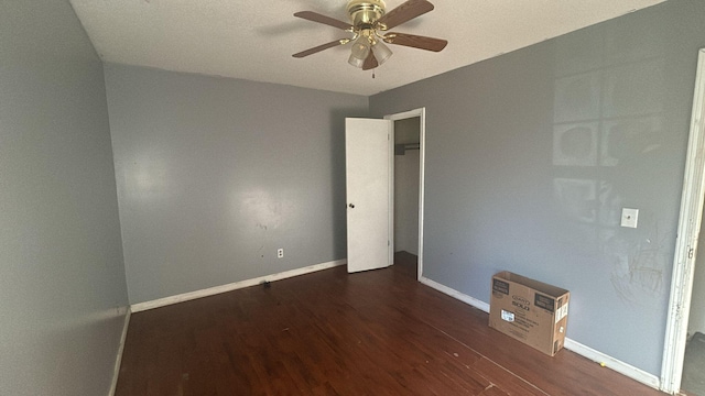 spare room featuring ceiling fan and dark wood-type flooring