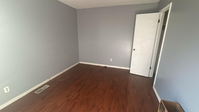 spare room featuring dark hardwood / wood-style flooring