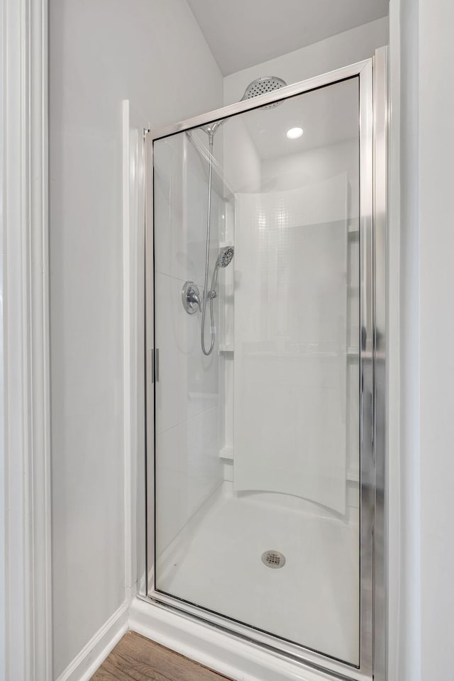 bathroom featuring wood-type flooring and an enclosed shower