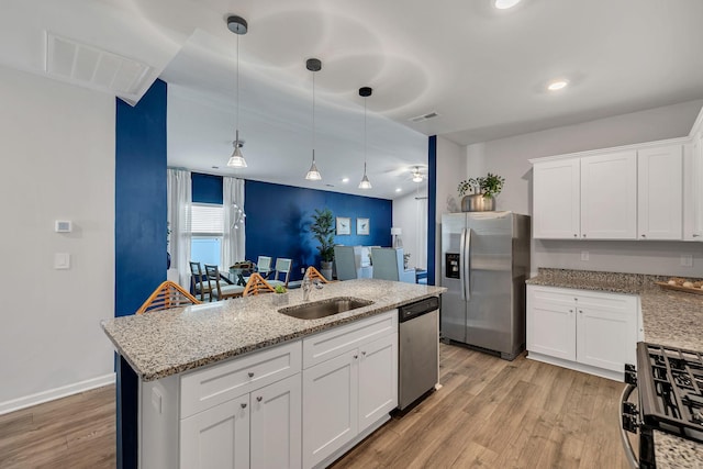 kitchen featuring white cabinets, light wood-type flooring, sink, and appliances with stainless steel finishes