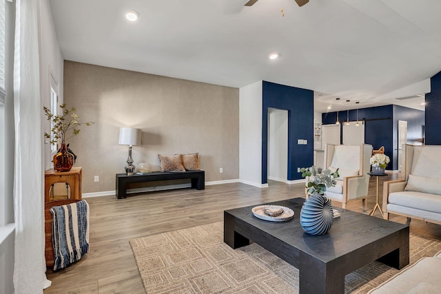 living room featuring light hardwood / wood-style floors and ceiling fan