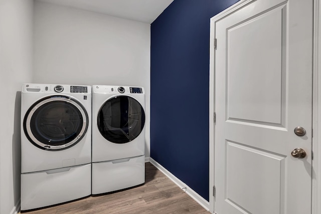 laundry area featuring independent washer and dryer and light hardwood / wood-style floors