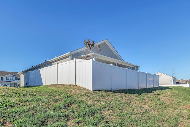 view of side of home with a yard