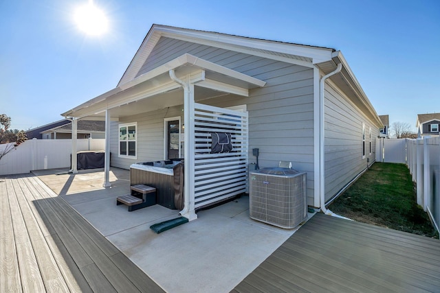 deck featuring cooling unit and a hot tub