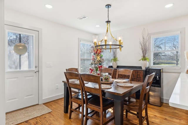 dining space featuring light hardwood / wood-style flooring and a chandelier