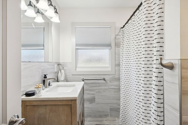 bathroom with a shower with shower curtain, vanity, and tile walls