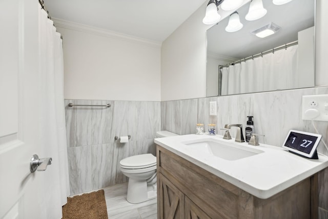 bathroom featuring vanity, toilet, tile walls, and ornamental molding